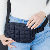 Babe Beachwear Lightweight Puffer Sling Bag in black worn over jeans with adjustable strap