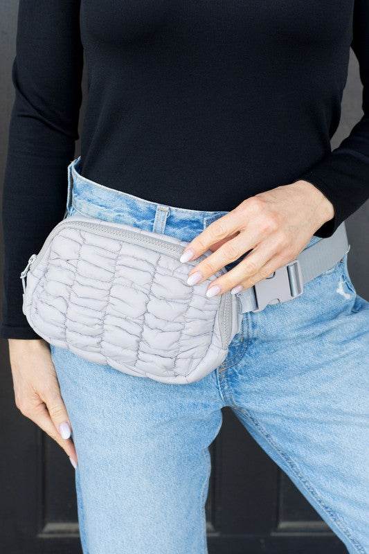 Lightweight Puffer Sling Bag by Babe Beachwaer worn on waist with quilted design in light gray