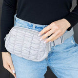 Lightweight Puffer Sling Bag by Babe Beachwaer worn on waist with quilted design in light gray