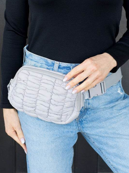 Lightweight Puffer Sling Bag by Babe Beachwaer worn on waist with quilted design in light gray