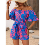 Babe Beachwear off-shoulder beach romper with pink and blue tropical leaf print and waist tie