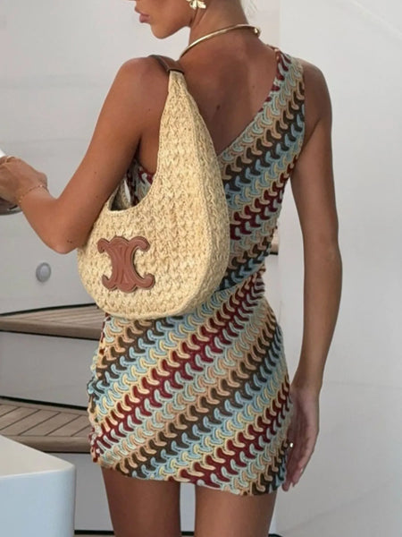 Babe Beachwear one shoulder mini dress with multicolor wave pattern and woman wearing a beige woven handbag