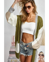 Trendsi oversized cardigan in green white and beige color block worn over white crop top and denim shorts