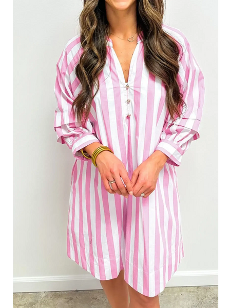 woman showing length of pink and white long sleeve vacation dress with vertical stripes and button detail