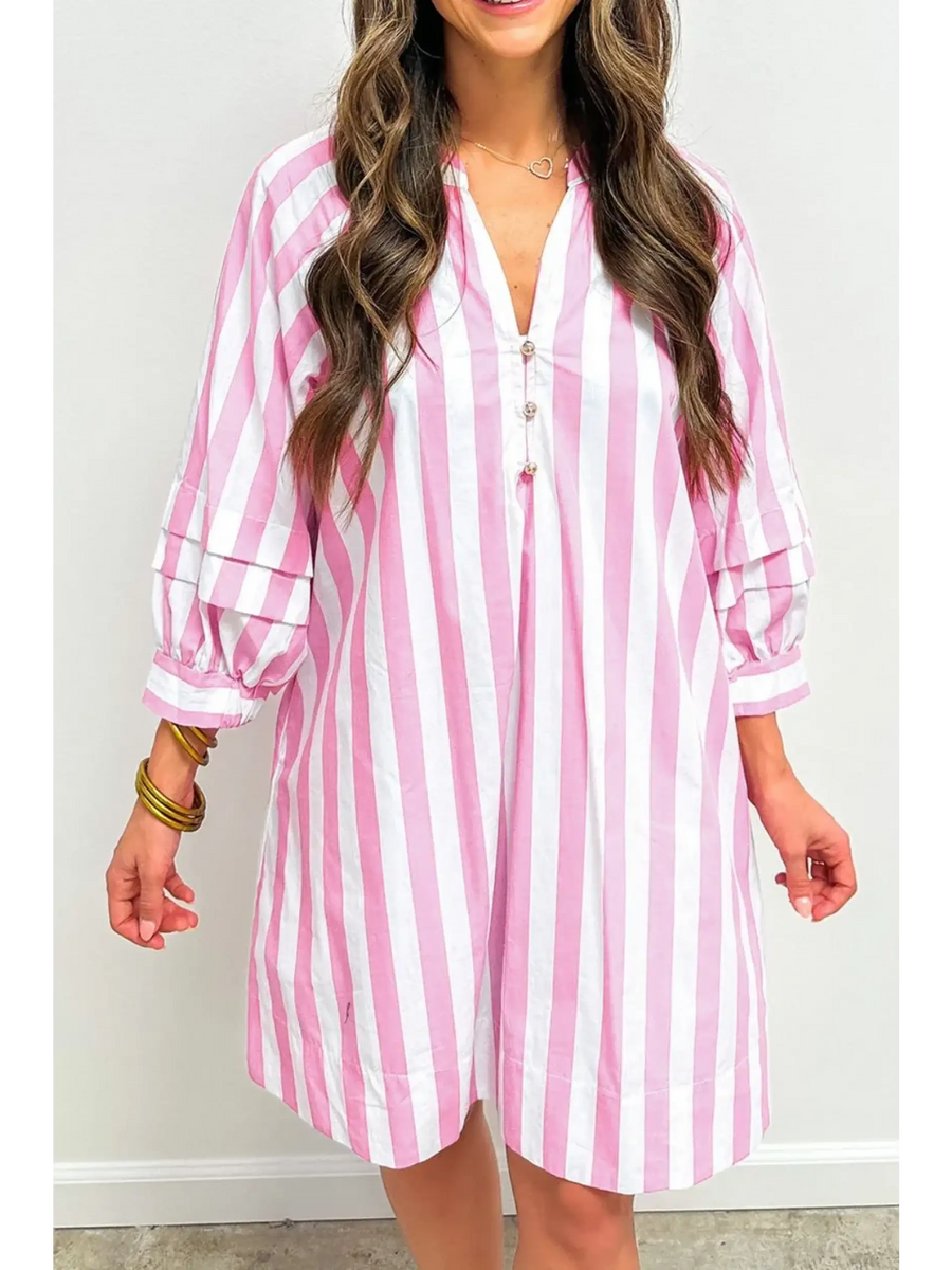 woman wearing a pink and white long sleeve vacation dress with vertical stripes and button detail