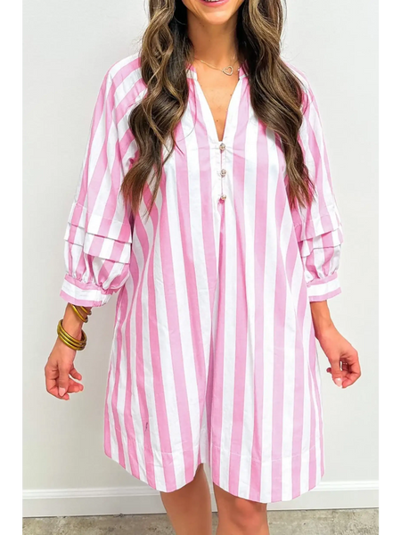 woman wearing a pink and white long sleeve vacation dress with vertical stripes and button detail