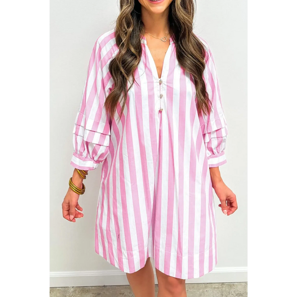 woman wearing a pink and white long sleeve vacation dress with vertical stripes and button detail
