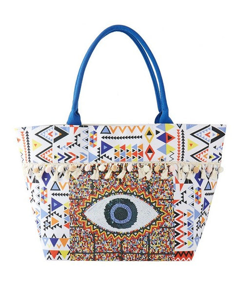 Babe Beachwear Pom Pom Evil Eye bag with colorful geometric patterns and blue handles