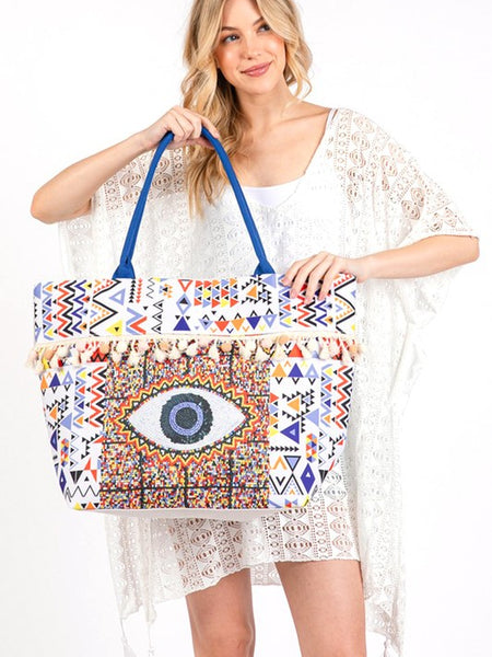 Pom Pom Evil Eye bag by Babe Beachwaer with colorful geometric patterns and blue handles
