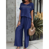 Babe Beachwear navy blue satin Pants Set with short sleeve top and wide leg pants styled with a woven handbag
