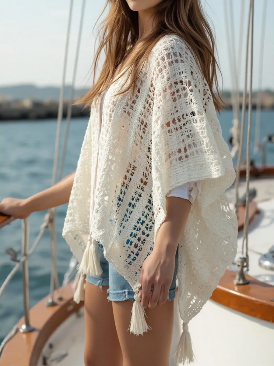 Trendsi long sleeve shawl lightweight knit poncho with tassels worn over white shirt and denim shorts