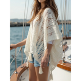 Trendsi long sleeve shawl lightweight knit poncho with tassels worn over white shirt and denim shorts