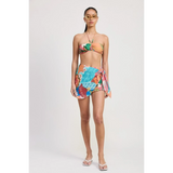 Emory Park Tangerine Bikini Bralette on model with tropical print sarong and white sandals