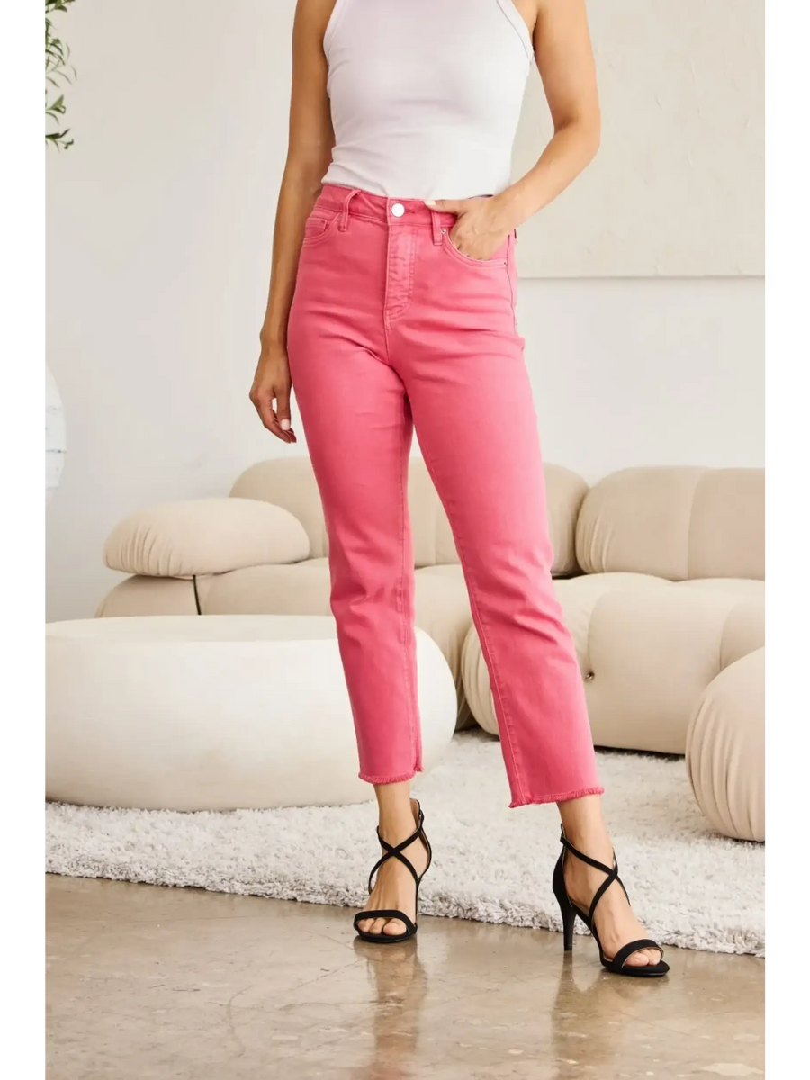 Trendsi pink tummy control high waist jeans worn with white tank top and black heels in modern living room