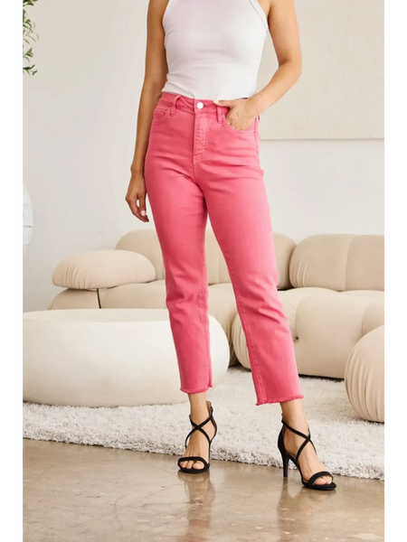 Trendsi pink tummy control high waist jeans worn with white tank top and black heels in modern living room
