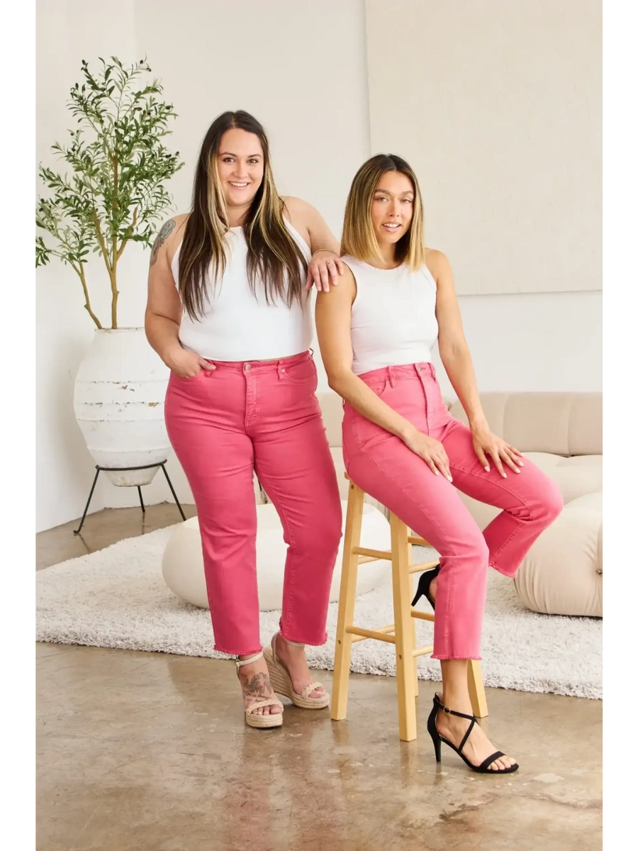 Two women modeling pink tummy control high waist jeans by Trendsi in a bright modern room