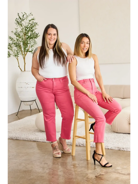 Two women modeling pink tummy control high waist jeans by Trendsi in a bright modern room