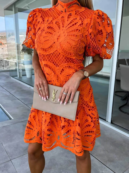 Trendsi orange midi dress with intricate cutout lace design and puff sleeves holding beige clutch