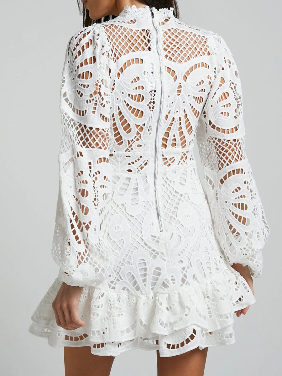 Babe Beachwear white lace mini cocktail dress with long sleeves and intricate cutout lace design