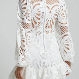 Babe Beachwear white lace mini cocktail dress with long sleeves and intricate cutout lace design