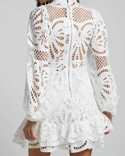 Babe Beachwear white lace mini cocktail dress with long sleeves and intricate cutout lace design