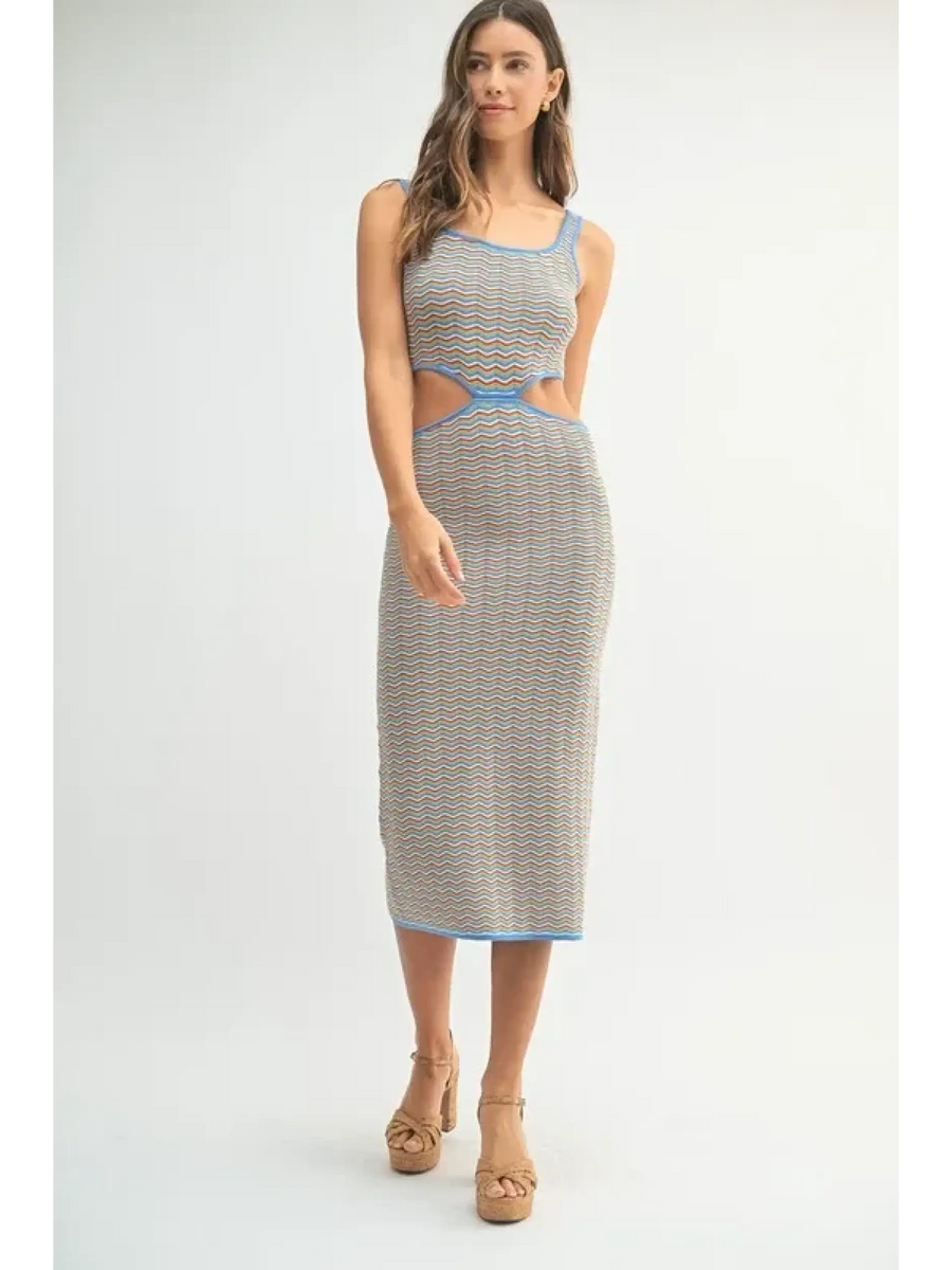 Woman wearing a chevron knit bodycon midi dress with blue trim and side cutouts