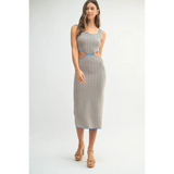Woman wearing a chevron knit bodycon midi dress with blue trim and side cutouts