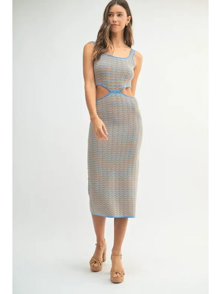Woman wearing a chevron knit bodycon midi dress with blue trim and side cutouts