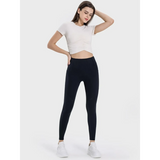  women's active leggings with pockets in black worn with white cropped top and sneakers