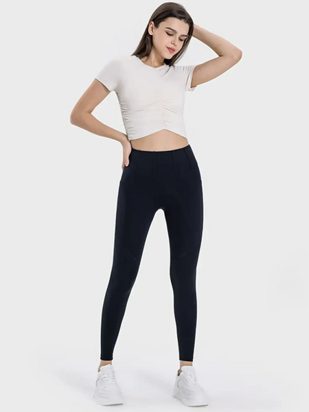  women's active leggings with pockets in black worn with white cropped top and sneakers