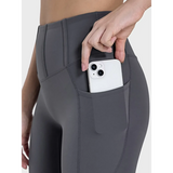  women's active leggings with pockets in dark gray showing phone stored in side pocket