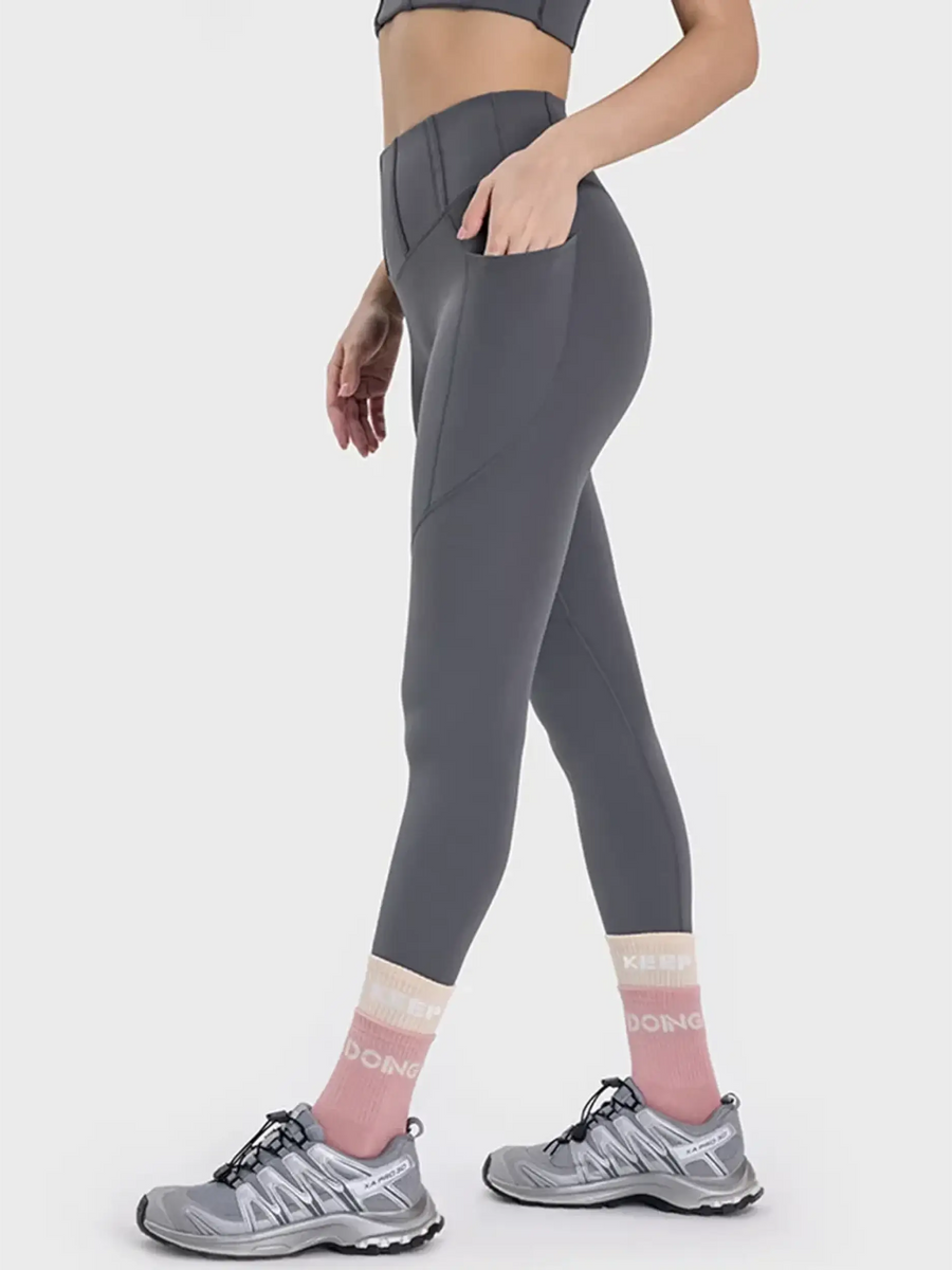 women's active leggings with pockets in gray worn with running shoes and socks
