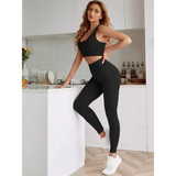 Trendsi women's compression leggings set in black with matching sports bra worn by model in modern kitchen