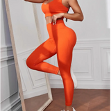 model wearing side view Trendsi women's compression leggings set in bright orange with matching sports bra and white sneakers