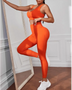 model wearing side view Trendsi women's compression leggings set in bright orange with matching sports bra and white sneakers