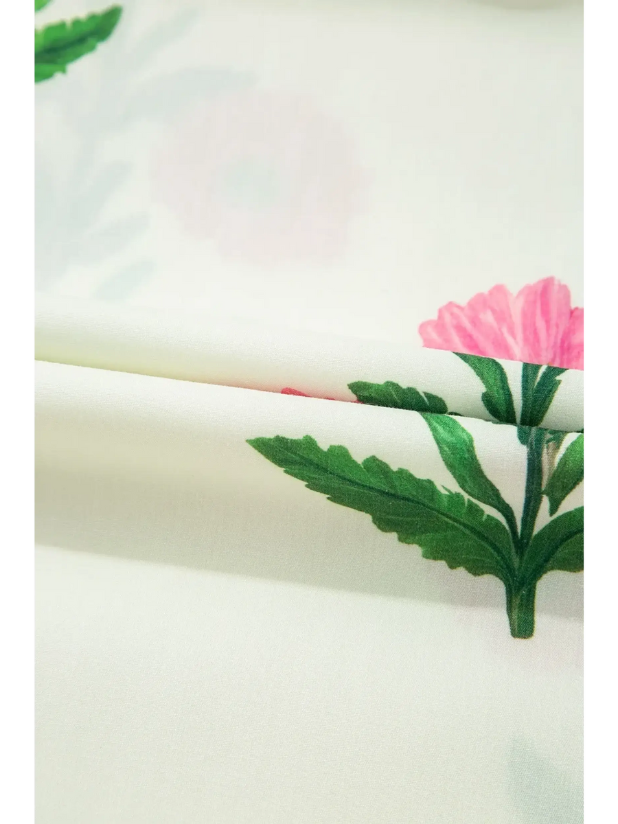 Close-up of floral fabric print with green leaves and pink flowers for women's flutter sleeve vacation dress