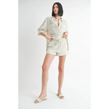 Woman wearing Emory Park women's linen shorts with a matching striped button-up shirt and slide sandals