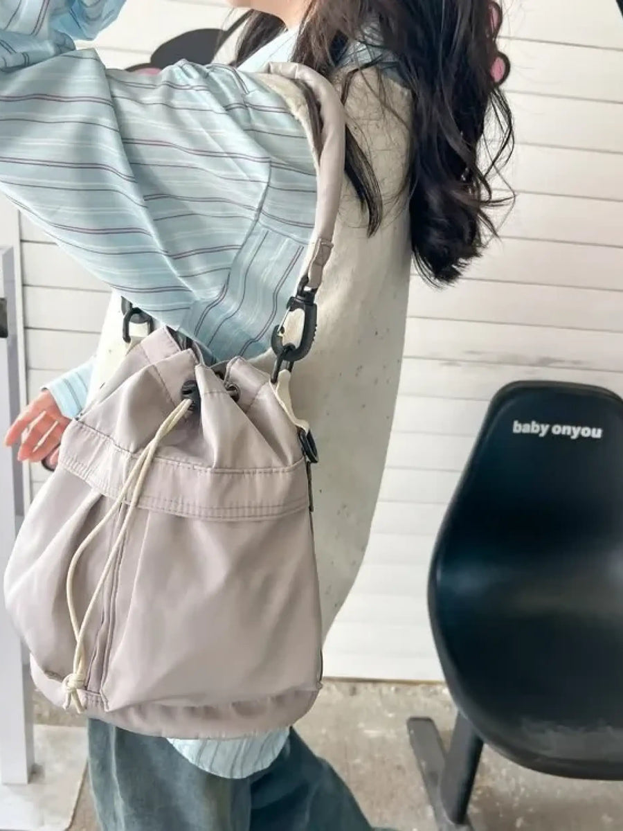 Trendsi women's nylon bucket bag in light beige worn on shoulder with adjustable strap