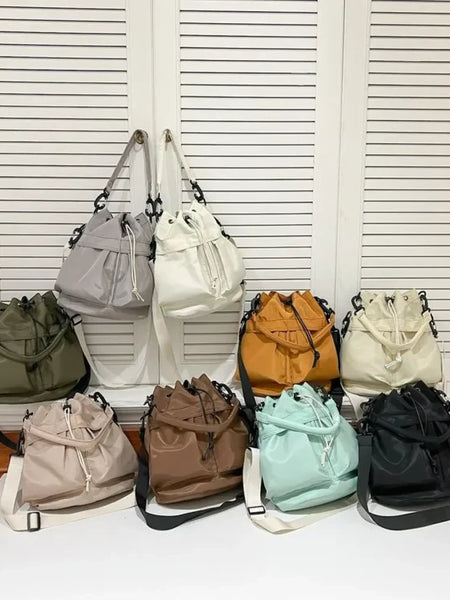 Collection of colorful women's nylon bucket bag styles by Trendsi displayed on table and hanging