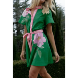 green women's resort wear short sleeve dress in green with pink floral accents and waist tie