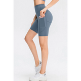 Babe Beachwear women's sports shorts with pockets in blue modeled with white sneakers