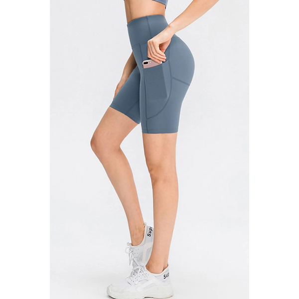 Babe Beachwear women's sports shorts with pockets in blue modeled with white sneakers