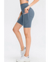 Babe Beachwear women's sports shorts with pockets in blue modeled with white sneakers