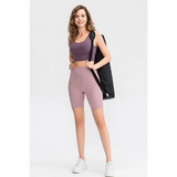 Woman wearing Babe Beachwear women's sports shorts with pockets in mauve and matching sports bra