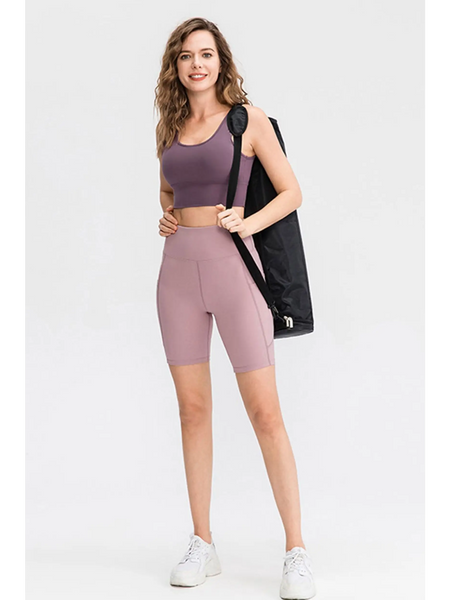 Woman wearing Babe Beachwear women's sports shorts with pockets in mauve and matching sports bra