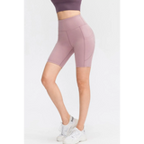 Babe Beachwear women's sports shorts with pockets in mauve stretchy fabric worn with white sneakers