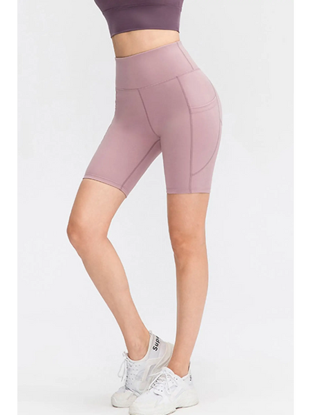 Babe Beachwear women's sports shorts with pockets in mauve stretchy fabric worn with white sneakers
