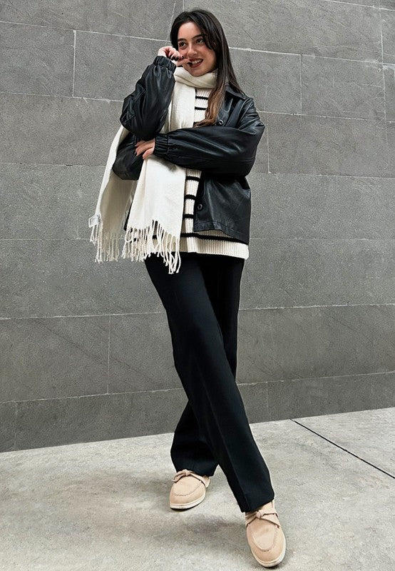 Rag Company women's suede loafers in beige worn with black pants and black jacket against gray wall