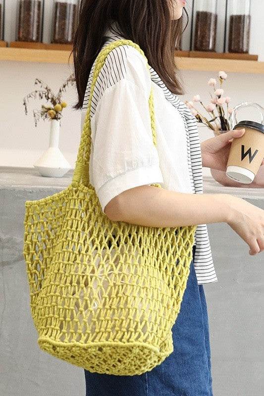 Miss Sparkling yellow braided net beach tote carried by a woman in casual outfit holding a coffee cup