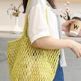 Miss Sparkling yellow braided net beach tote carried by a woman in casual outfit holding a coffee cup